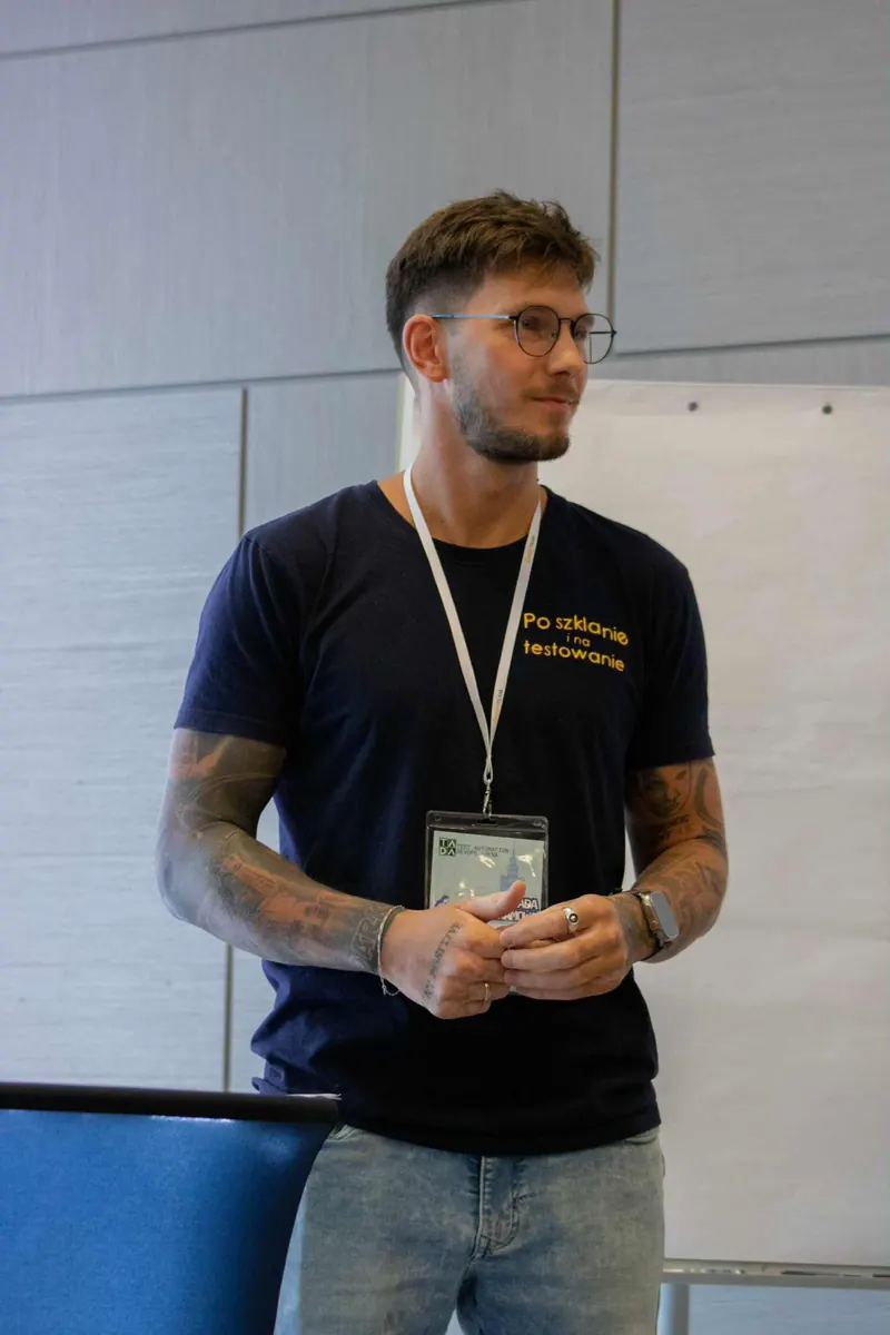 Jakub Konicki w koszulce podcastu „Po szklanie i na testowanie” podczas wystąpienia